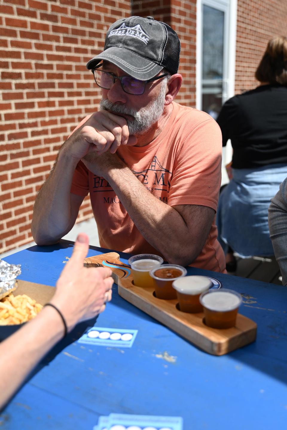 George Ranville, of Mackinaw City, Michigan, discusses the beers at Indian Lake Brewing Company with his wife, Gail, on April 8, 2024. The Ranvilles own a brewery in Michigan and have traveled to breweries in the path of totality for the last two total solar eclipses.