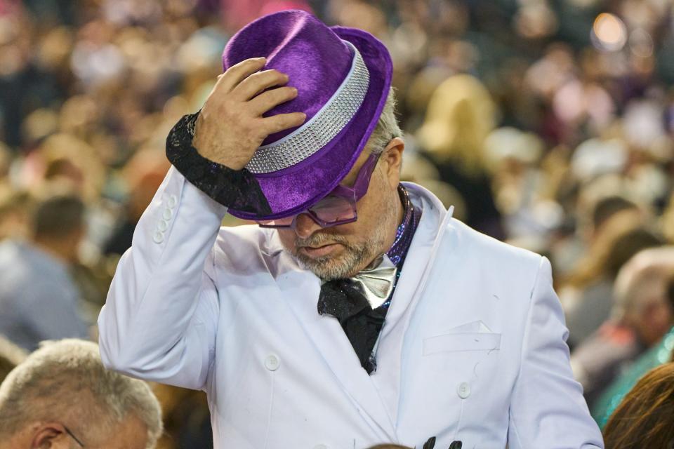 An Elton John fan stands and puts his hat on before Elton John takes the stage for his "Farewell Yellow Brick Road The Final Tour" on Friday, Nov. 11, 2022, at Chase Field in Phoenix.