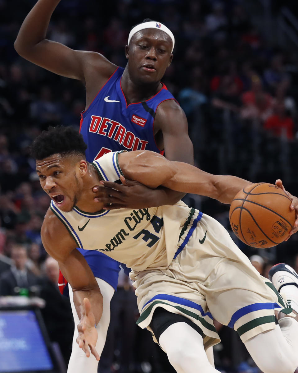 Detroit Pistons forward Sekou Doumbouya reaches in on Milwaukee Bucks forward Giannis Antetokounmpo (34) during the first half of an NBA basketball game, Thursday, Feb. 20, 2020, in Detroit. (AP Photo/Carlos Osorio)