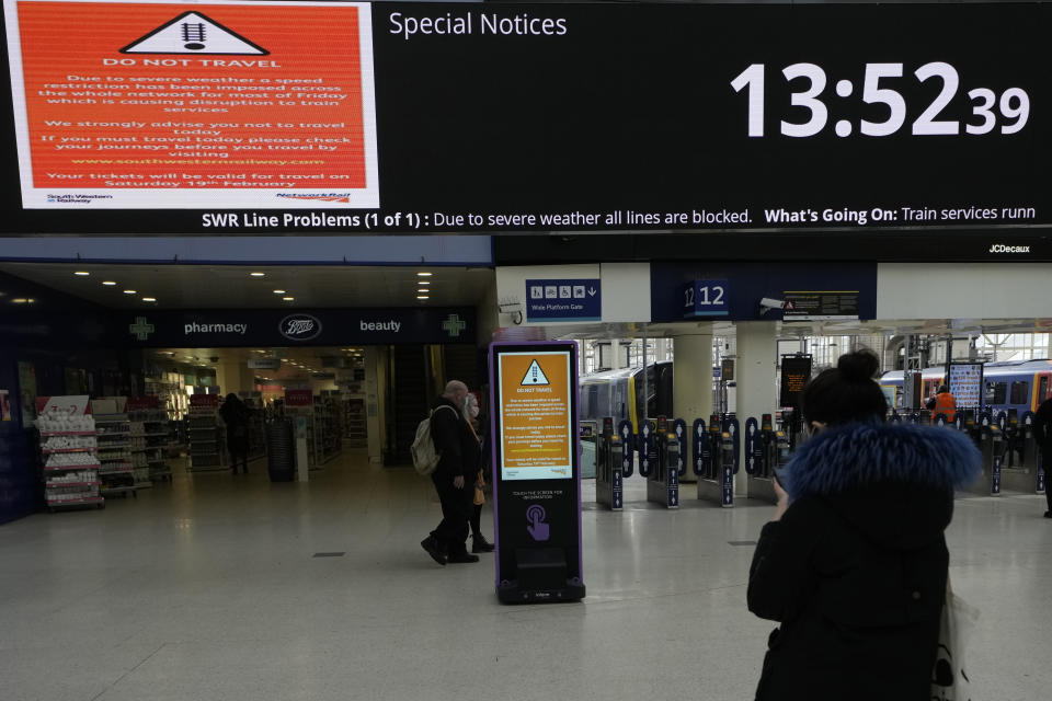 Signs showing cancellations across the board as commuters look at options as all trains from Waterloo Station are cancelled due to sever weather n London, Friday, Feb. 18, 2022. Millions of Britons are being urged to cancel travel plans and stay indoors Friday amid fears of high winds and flying debris as the second major storm this week prompted a rare "red" weather warning across southern England (AP Photo/Alastair Grant)