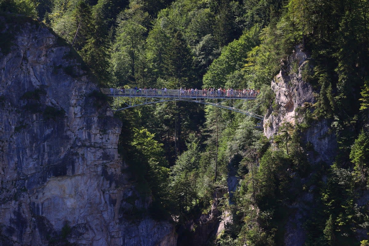 Tourists stand on the Marienbr'cke bridge, near the Neuschwanstein castle, in Schwangau, Germany (AP)