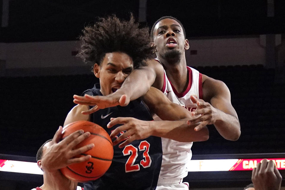 Cal State Fullerton guard Tory San Antonio, left, and Southern California forward Joshua Morgan reach for a rebound during the first half of an NCAA college basketball game Wednesday, Dec. 7, 2022, in Los Angeles. (AP Photo/Mark J. Terrill)