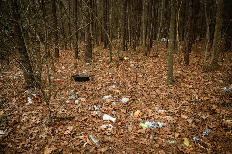 Trash is littered across the ground along Buhmann Drive in Fayetteville.