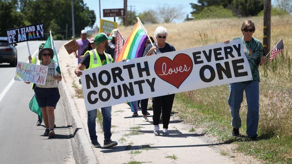 Demonstrators walk to the Vineyard Drive Highway 101 overpass in Templeton for a rally on May 10, 2023, in response to a social media post showing two people holding an “Embrace white pride” banner there last week.