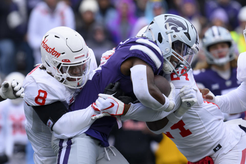Kansas State running back DJ Giddens, center, is wrapped up by Houston linebacker Malik Robinson (8) and Houston defensive back Adari Haulcy (24) during the first half of an NCAA college football game in Manhattan, Kan., Saturday, Oct. 28, 2023. (AP Photo/Reed Hoffmann)