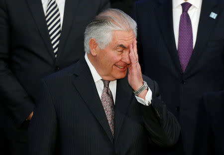 Secretary of State Rex Tillerson wipes his face during the delegation photo with leaders from Global Coalition working to Defeat ISIS at the State Department in Washington, U.S., March 22, 2017. REUTERS/Joshua Roberts