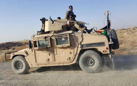 Afghan security forces sit on top of a vehicle as they patrol outside of Kunduz city, October 1, 2015. Afghan troops recaptured the center of the strategic northern city of Kunduz on Thursday amid fierce clashes with Taliban militants, three days after losing the provincial capital in a humbling defeat for Kabul and its U.S. allies. REUTERS/Hamid Shalizi