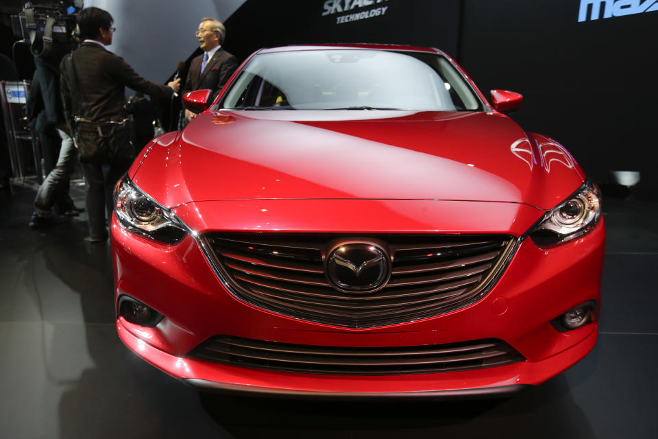 Mazda CEO Takashi Yamanouchi is interviewed while the Mazda6 is shown during it's North American debut at the LA Auto Show in Los Angeles, Thursday, Nov. 29, 2012. (AP Photo/Chris Carlson)