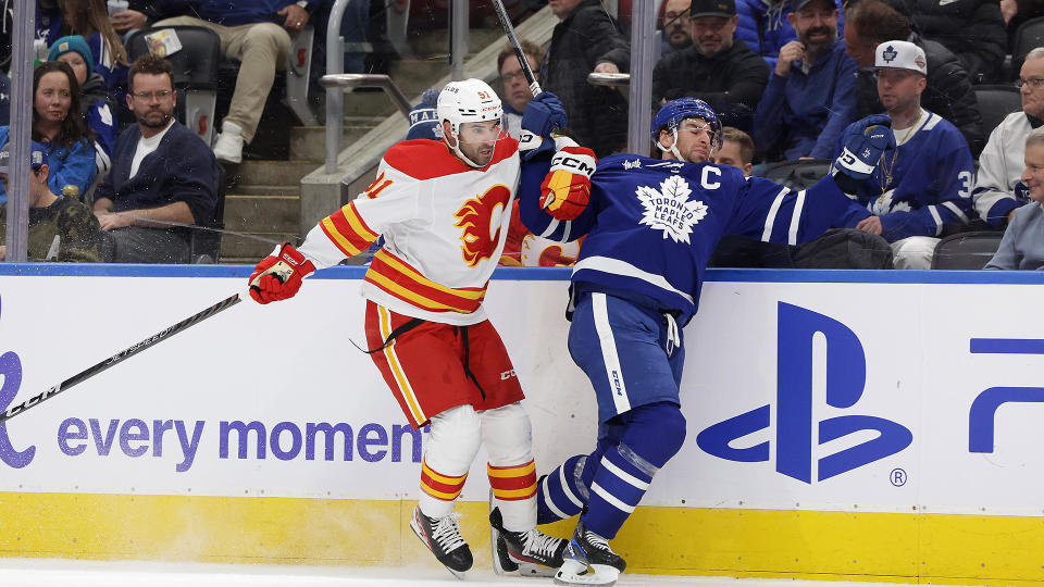 Maple Leafs captain John Tavares (91) fights through a check from Flames forward Nazem Kadri. (Steve Russell/Toronto Star via Getty Images)