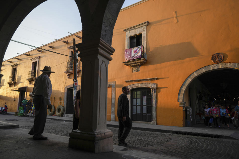 Pedestrians walk in Maravatio, Michoacan state, Mexico,Tuesday, Feb. 27, 2024. Two mayoral hopefuls in this city were gunned down the previous day within hours of each other. (AP Photo/Fernando Llano)