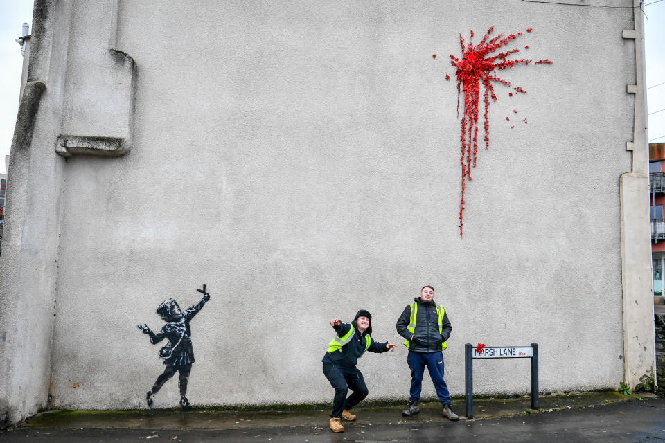 L'ultima creazione dello street artist britannico sulla facciata di un edificio a Bristol, sua città natale in Inghilterra: una bambina con una fionda di fronte a un’esplosione rossa, fatta di petali e fiori di plastica, forse il cuore infranto di Cupido. (Photo by Ben Birchall/PA Images via Getty Images)