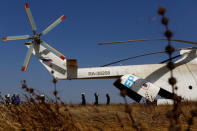 Men unload boxes of nutritional supplements from an helicopter prior to a humanitarian food distribution carried out by the United Nations World Food Programme (WFP) in Thonyor, Leer state, South Sudan, February 25, 2017. REUTERS/Siegfried Modola