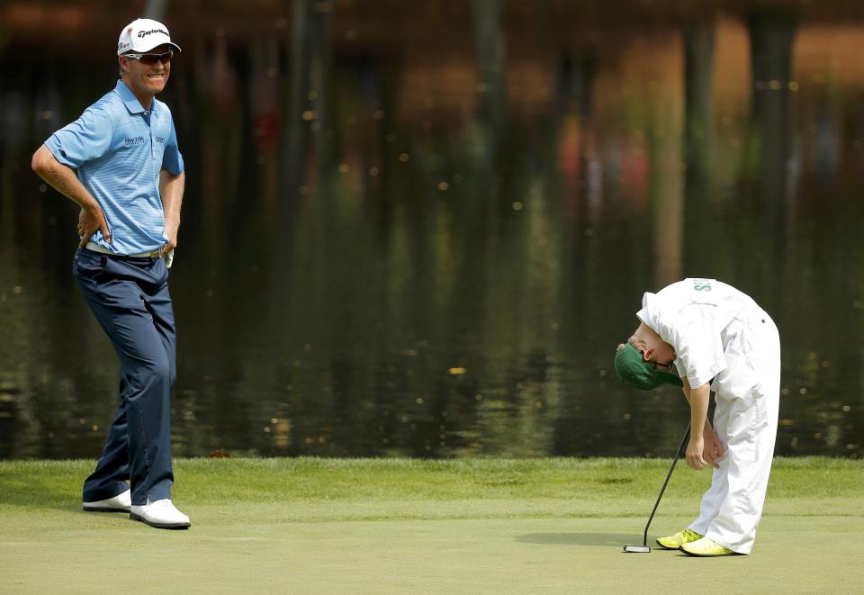 John Senden of Australia looks on as his son Jacob reacts to a missed putt during the par 3 event held ahead of the 2015 Masters at Augusta National Golf Course in Augusta, Georgia April 8, 2015. REUTERS/Brian Snyder