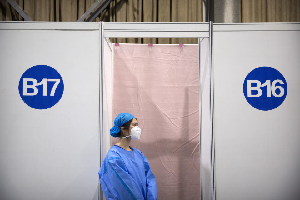 A worker waits outside an injection booth during a COVID-19 vaccination session for resident foreign journalists at a vaccination center in Beijing, Tuesday, March 23, 2021. Chinese medical firm Sinovac said its COVID-19 vaccine is safe in children ages 3-17, based on preliminary data, and it has submitted the data to Chinese drug regulators. State-owned Sinopharm, who has two COVID-19 vaccines, is also investigating the effectiveness of its vaccines in children. (AP Photo/Mark Schiefelbein)