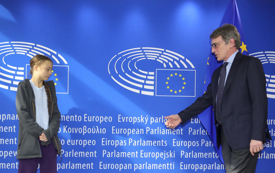 European Parliament President David Sassoli, right, reaches out to shake hands with Swedish climate activist Greta Thunberg during arrival for a meeting of the Environment Council at the European Parliament in Brussels, Wednesday, March 4, 2020. Climate activists and Green members of the European Parliament are urging the European Union to be more ambitious as the bloc gets ready to unveil plans for a climate law to cut greenhouse gas emissions to zero by mid-century. (AP Photo/Olivier Matthys)