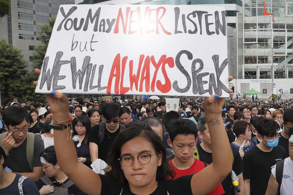 A protester holds a placard as she takes part in a march with thousands of others in Sha Tin District in Hong Kong, Sunday, July 14, 2019. Opponents of a proposed Hong Kong extradition law have begun a protest march, adding to an outpouring of complaints the territory's pro-Beijing government is eroding its freedoms and autonomy. (AP Photo/Kin Cheung)