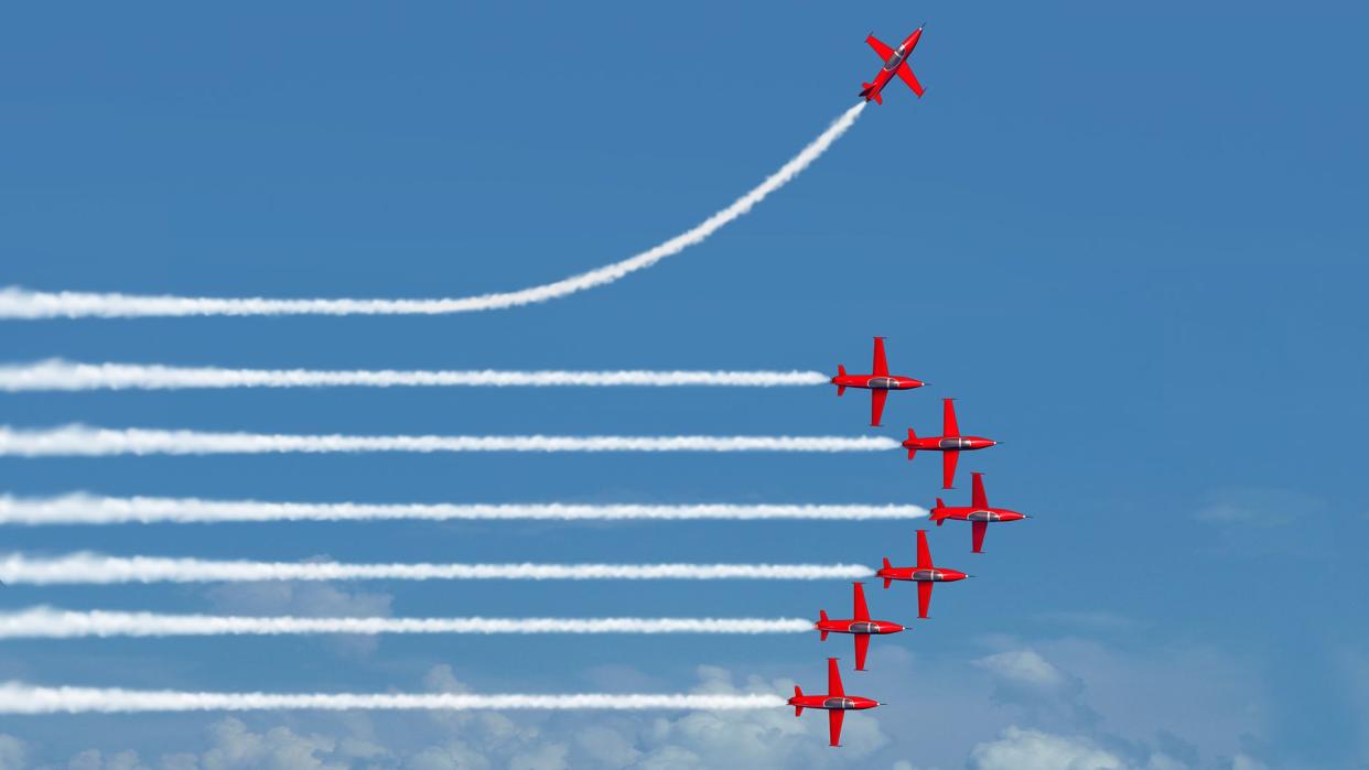 Charting a different path business concept as an independent free thinker idea with air show jet airplanes in an organized formation with one individual plane setting a new course with 3D illustration elements.