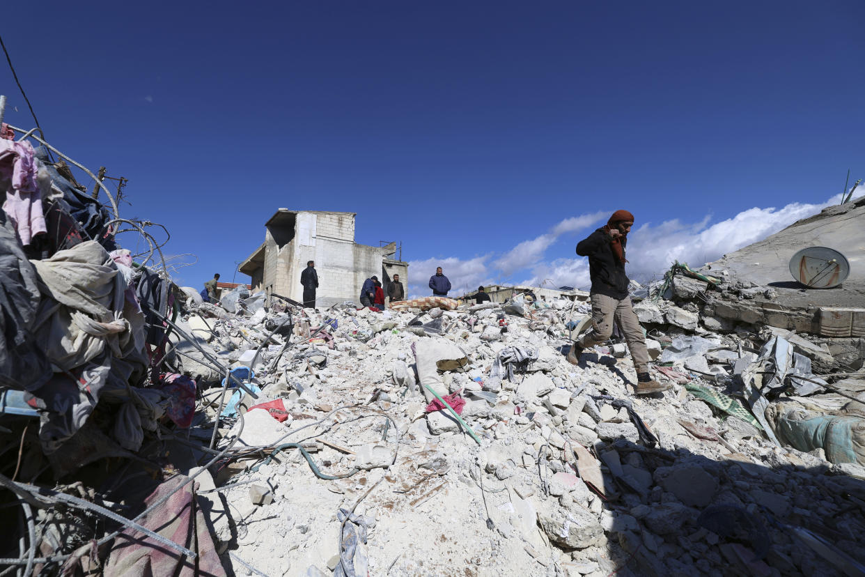 People search through the rubble of collapsed buildings where a newborn girl was found in the town of Jinderis, Aleppo province, Syria, Tuesday, Feb. 7, 2023. Residents in the northwest Syrian town discovered the crying infant, whose mother gave birth to her while buried underneath the rubble of a five-story apartment building leveled by this week's devastating earthquake, relatives and a doctor say. (AP Photo/Ghaith Alsayed)