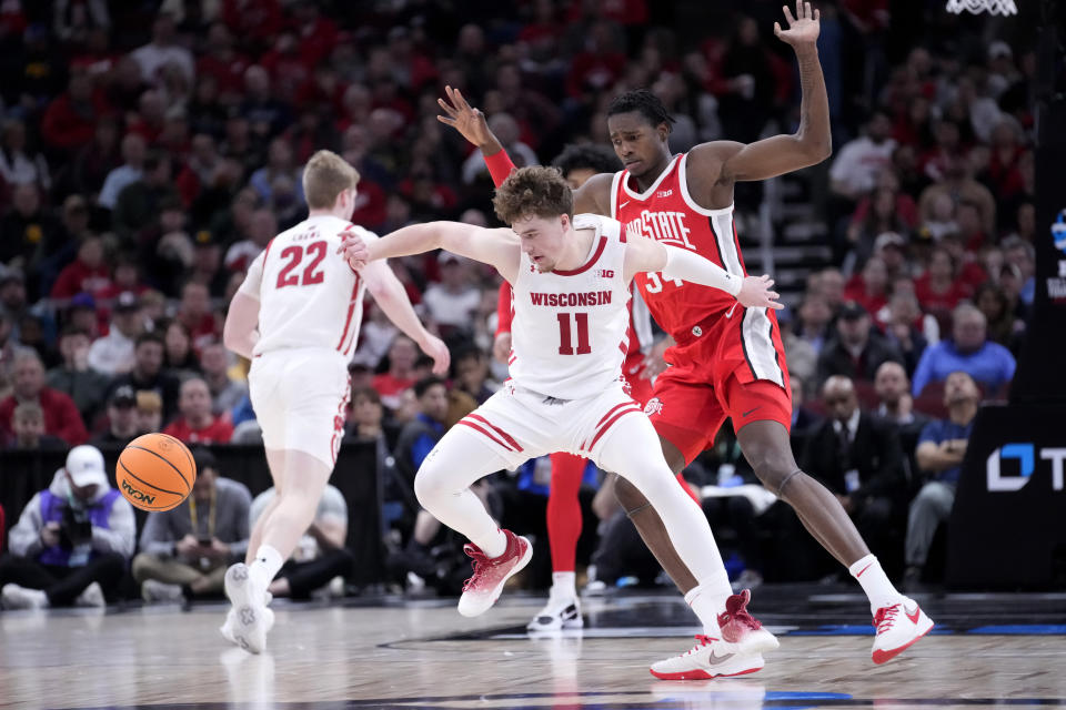 Wisconsin's Max Klesmit (11) loses control of the ball as Ohio State's Felix Okpara defends during the first half of an NCAA college basketball game at the Big Ten men's tournament, Wednesday, March 8, 2023, in Chicago. (AP Photo/Charles Rex Arbogast)