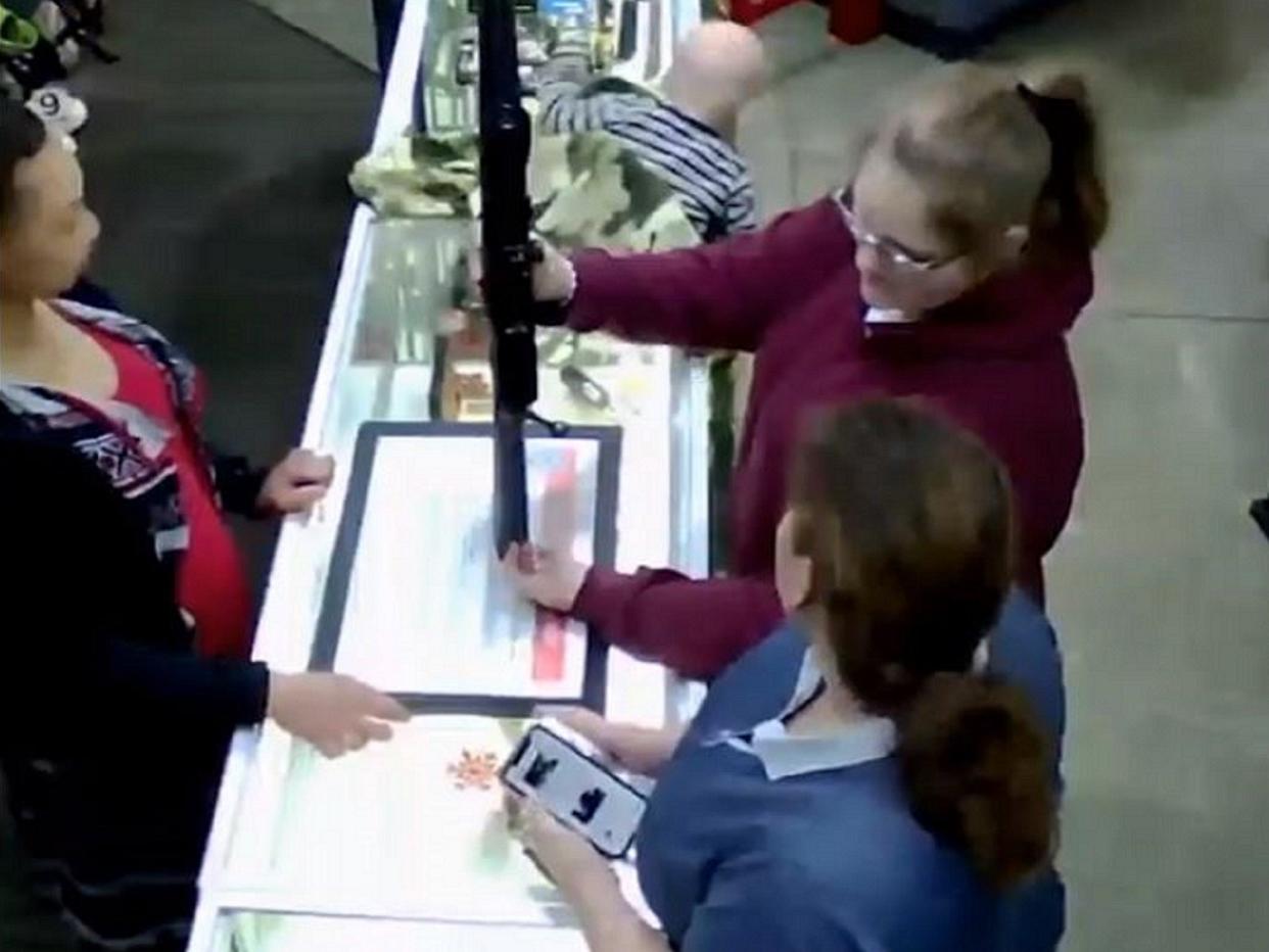 Still image from CCTV footage of a baby falling off a counter at Family Pawn in Utah, US, while two women look at a rifle: Bill Reel