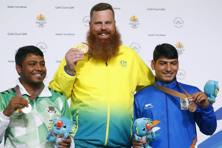 Shooting - Gold Coast 2018 Commonwealth Games - Men's 50m Pistol - Final - Belmont Shooting Centre - Brisbane, Australia - April 11, 2018. Gold medallist Daniel Repacholi of Australia flanked by silver medallist Shakil Ahmed of Bangladesh and bronze medallist Om Mitharval of India, pose with their medals and Borobi plush dolls. REUTERS/Eddie Safarik