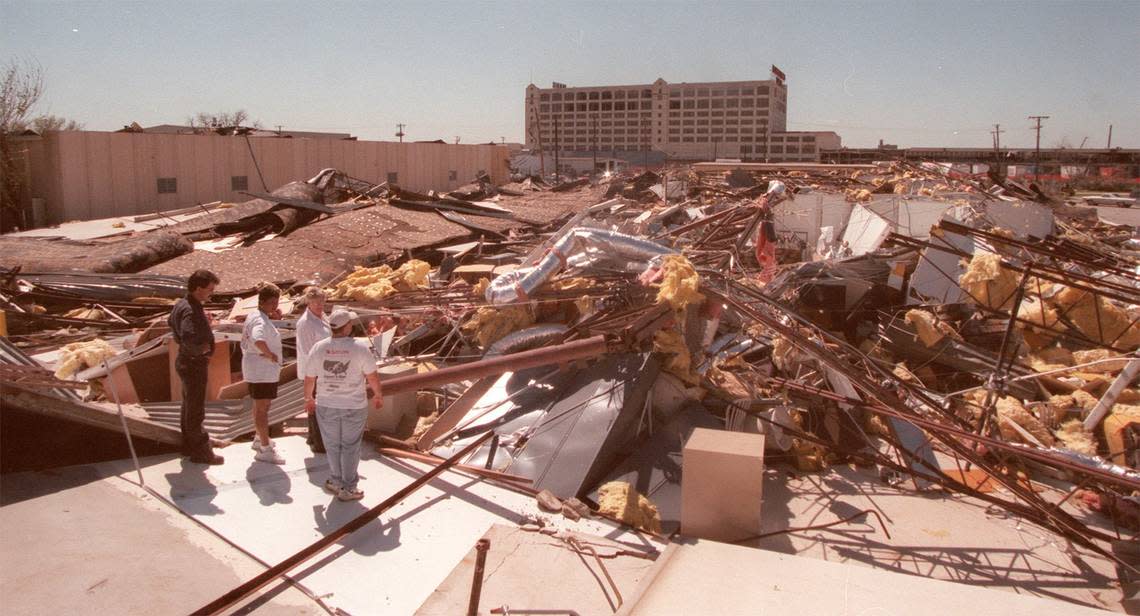 Employees of The Sweet Shop candy factory inspect the wreckage the day after a tornado on March 28, 2000, in Fort Worth. The F2 twister crushed homes in the Linwood neighborhood and pummeled a warehouse behind the Montgomery Ward building along West Seventh Street before hitting Sweet Shop and crossing Trinity River toward downtown. Today, the Sweet Shop site is the Left Bank next to Tom Thumb.