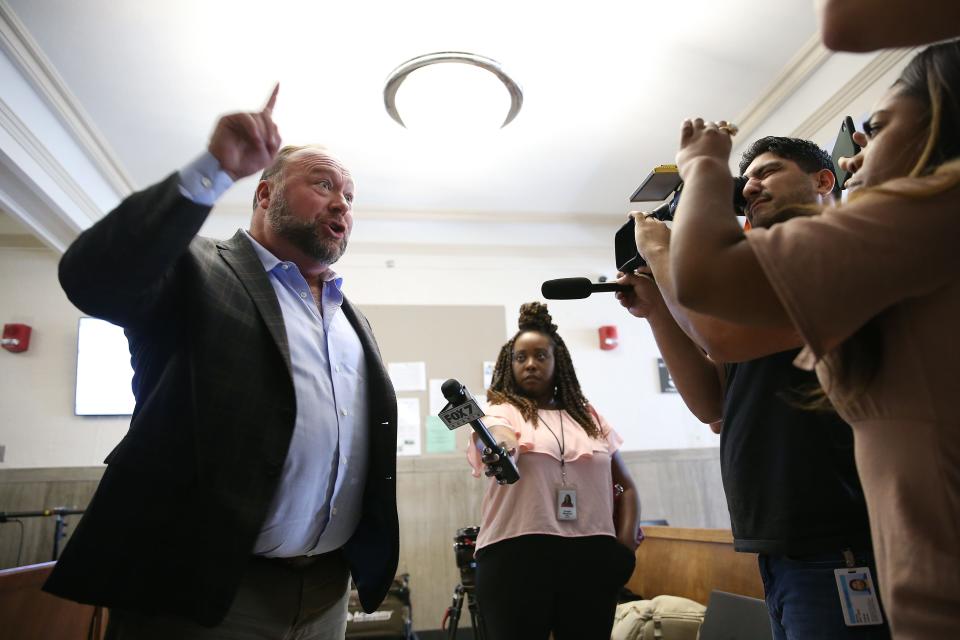 Alex Jones talks to the media during a midday break during the trial at the Travis County Courthouse on Tuesday. Jones has been found to have defamed the parents of a Sandy Hook student for calling the attack a hoax.