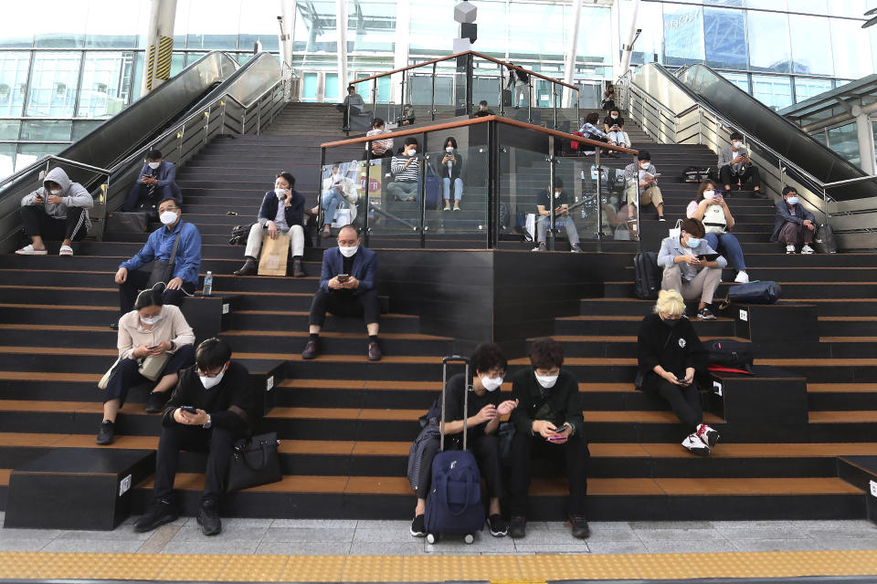 People wearing face masks to help protect against the spread of the coronavirus wait for their trains ahead of the upcoming Chuseok holiday, the Korean version of Thanksgiving Day, at the Seoul Railway Station in Seoul, South Korea, Tuesday, Sept. 29, 2020. (AP Photo/Ahn Young-joon)