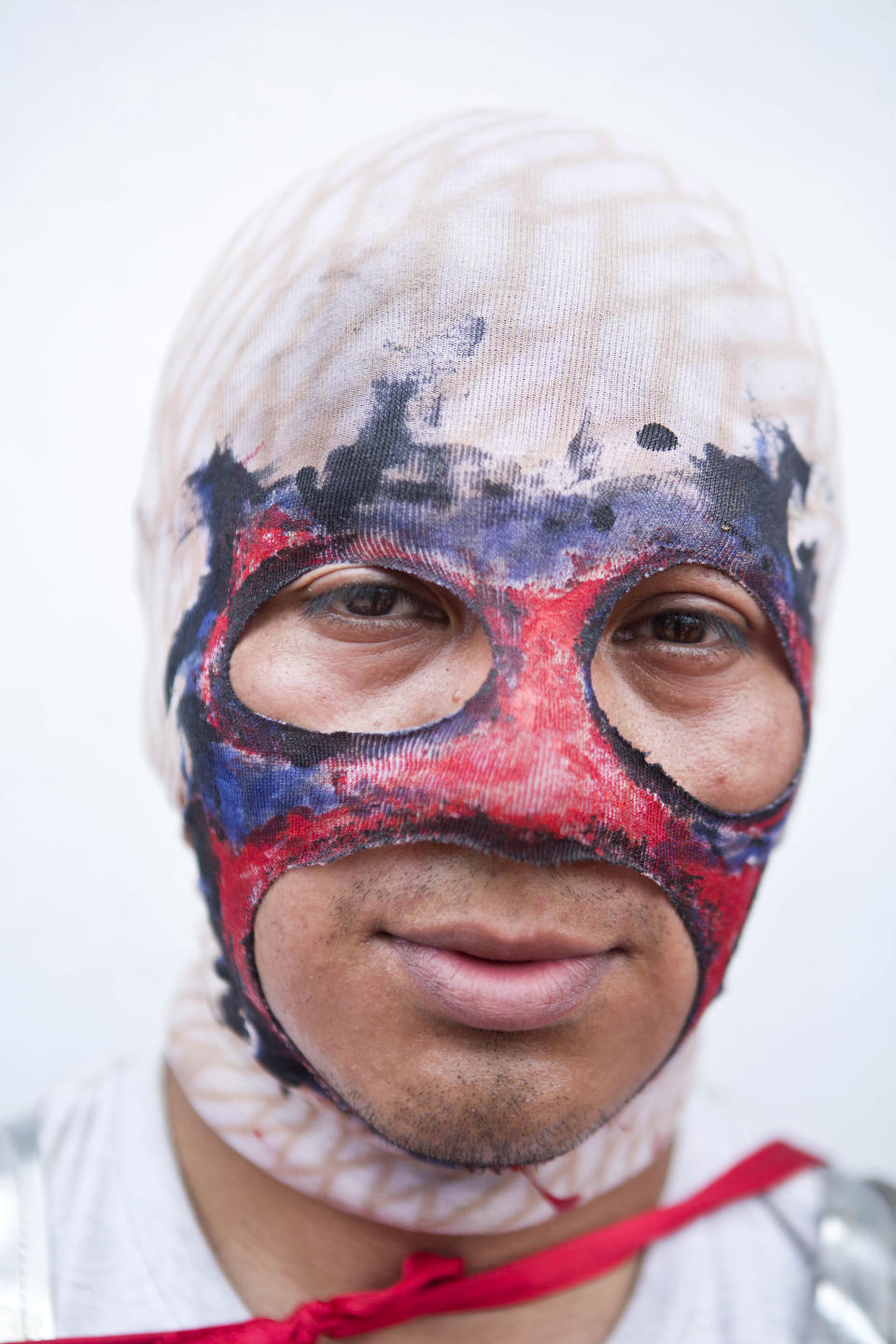 In this April 18, 2014 photo, a youth with a mask poses for a picture during a break while participating in "Los Encadenados," or The Chained Ones procession on Good Friday during Holy Week in Masatepe, Nicaragua. The youth played the part of the crowd who used chains to carry away Jesus and Judas. More than 900 people participated in the event this year, some to keep the tradition alive and others to repay a promise to God. (AP Photo/Esteban Felix)