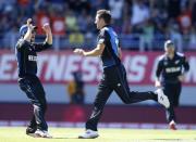 New Zealand's Trent Boult (C) celebrates dismissing Australia's Mitchell Stark with Kane Williamson (L) in their Cricket World Cup match in Auckland February 28, 2015. REUTERS/Nigel Marple
