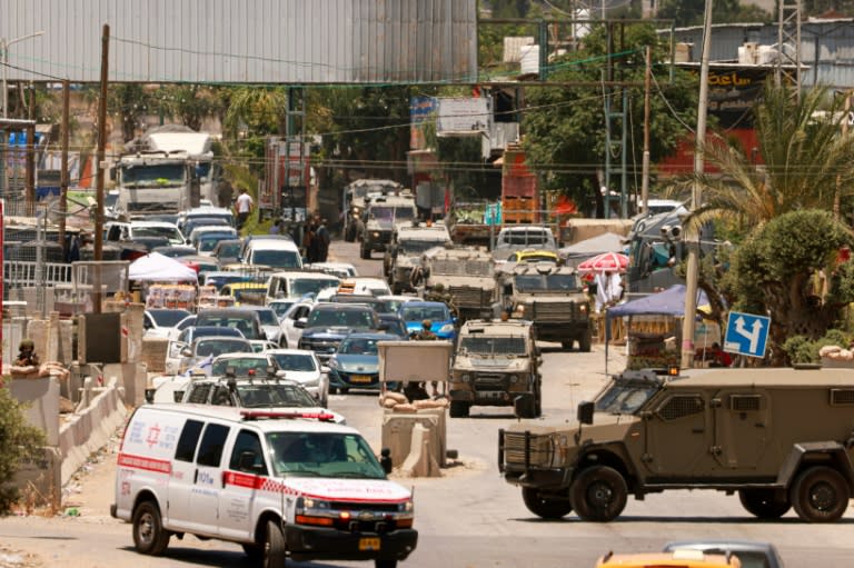 Una ambulancia de Magen David Adom y unos vehículos militares israelíes bloquean el tráfico en la localidad cisjordana de Qalqilyah tras un ataque el 22 de junio de 2024 (Jaafar Ashtiyeh)