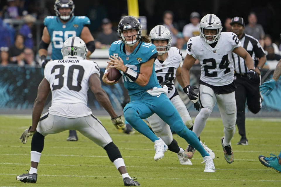 Jacksonville Jaguars quarterback Trevor Lawrence (16) scrambles against Las Vegas Raiders safety Duron Harmon (30) in the first half of an NFL football game Sunday, Nov. 6, 2022, in Jacksonville, Fla. (AP Photo/John Raoux)