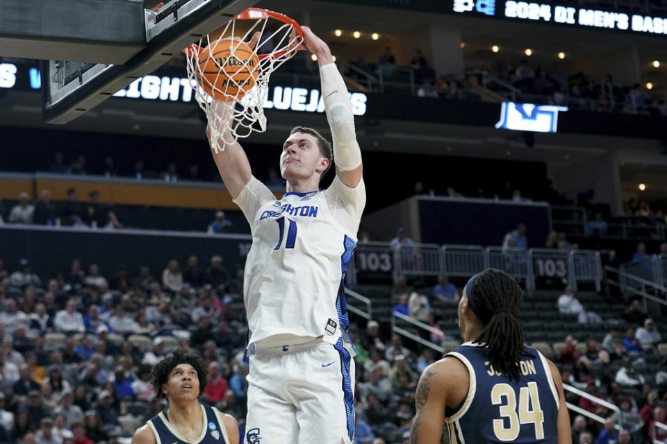 Creighton’s Ryan Kalkbrenner (11) dunks over Akron’s Nate Johnson (34) during the second half of a first-round college basketball game in the NCAA Tournament, Thursday, March 21, 2024, in Pittsburgh. (AP Photo/Matt Freed)