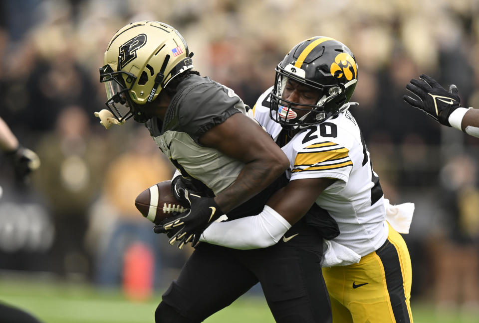 Iowa defensive back Kael Kolarik (20) tackles Purdue wide receiver Deion Burks (4) during the second half of an NCAA college football game, Saturday, Nov. 5, 2022, in West Lafayette, Ind. (AP Photo/Marc Lebryk)