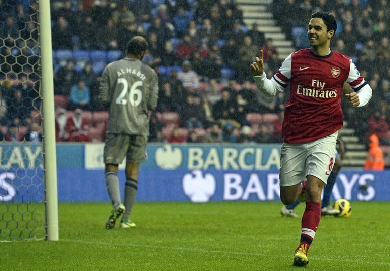 Arsenal's midfielder Mikel Arteta (R) celebrates scoring the opening goal on December 22, 2012. Arsenal climbed to third place in the Premier League as Arteta's second half penalty sealed a 1-0 win over Wigan at the DW Stadium