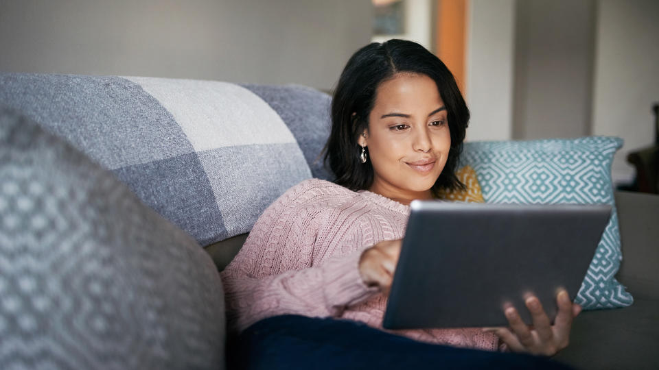 Shot of an attractive young woman using a digital tablet at home.