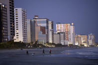 People walk on the beach Saturday, Feb. 4, 2023, in Myrtle Beach, S.C. Earlier in the day, a Chinese balloon was shot down in the area. (AP Photo/Chris Seward)