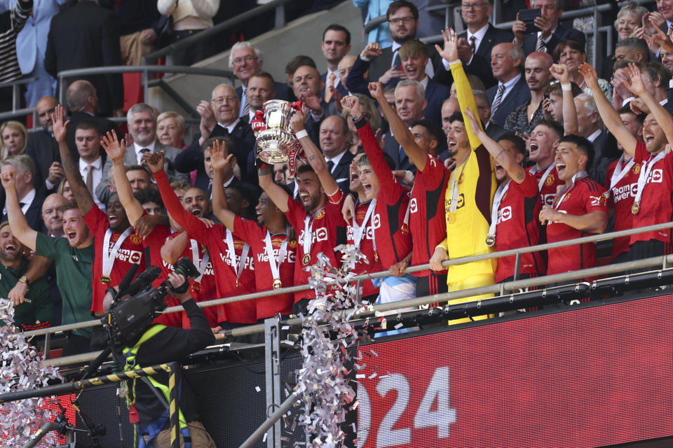 Manchester United's players celebrate with the trophy after winning the English FA Cup final soccer match between Manchester City and Manchester United at Wembley Stadium in London, Saturday, May 25, 2024. (AP Photo/Ian Walton)