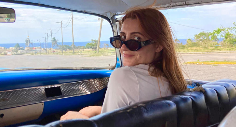 Hannah Millington, pictured in the front of a car in Cuba. (Supplied)