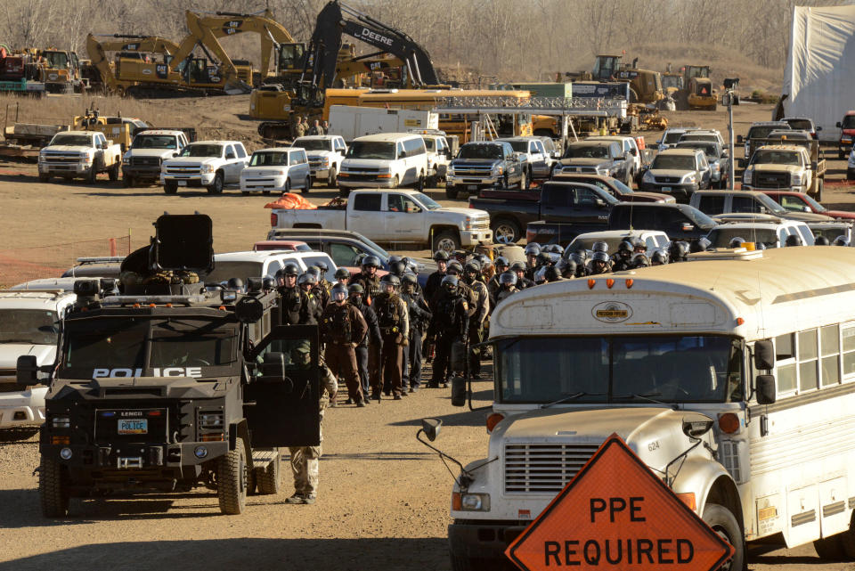 Police stand guard in a Dakota Access pipeline construction facility.