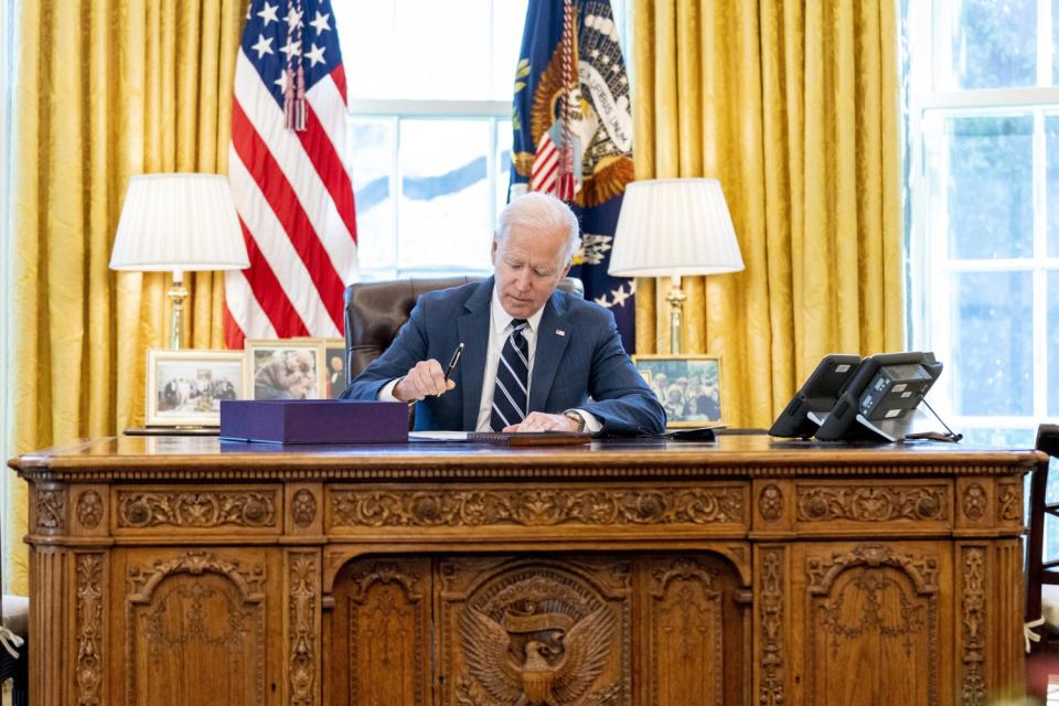 President Biden signs the American Rescue Plan, a coronavirus relief package, in the Oval Office on March 11.