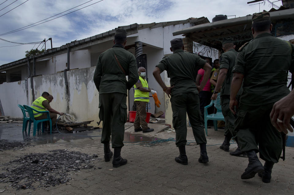 Army officers arrive as police officers collect evidence from a site of a gun battle between troops and suspected Islamist militants in Kalmunai, Sri Lanka, Sunday, April 28, 2019. Police in Ampara showed The Associated Press on Sunday the explosives, chemicals and Islamic State flag they recovered from the site of one security force raid in the region as Sri Lanka's Catholics celebrated at televised Mass in the safety of their homes. (AP Photo/Gemunu Amarasinghe)