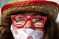 A woman wearing a face mask to protect agains coronavirus and a glasses with stickers in an old Belarusian national flag colors attends an opposition rally to protest the official presidential election results in Minsk, Belarus, Saturday, Sept. 26, 2020. Hundreds of thousands of Belarusians have been protesting daily since the Aug. 9 presidential election. (AP Photo/TUT.by)