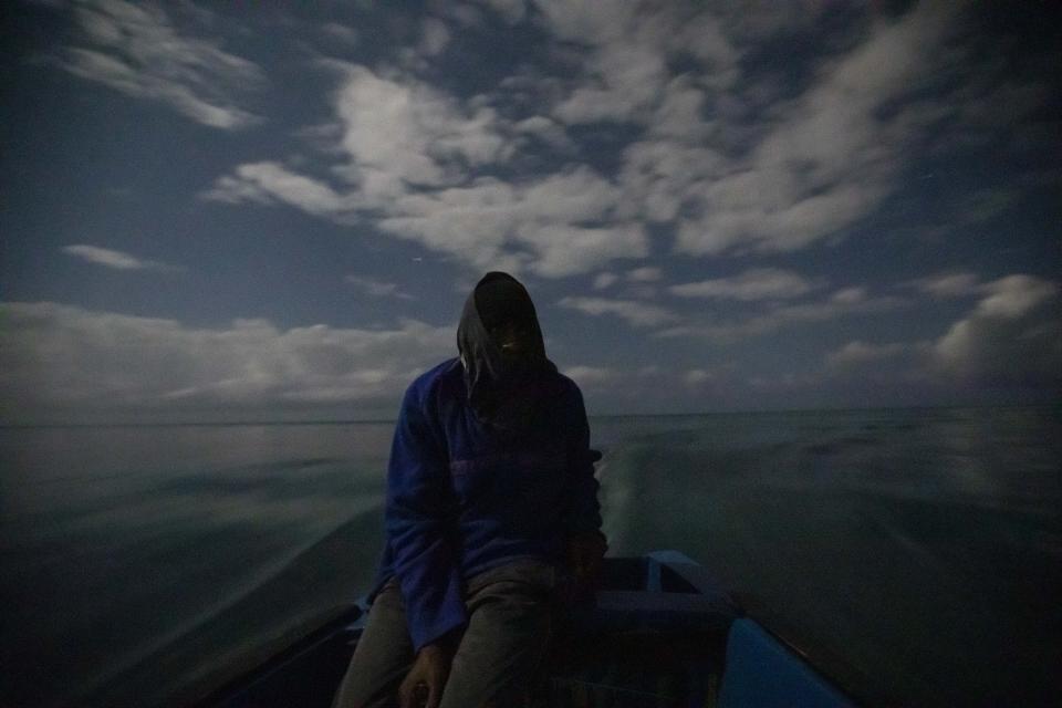 White River Fish Sanctuary warden Mark Lobban steers the boat under moonlight while patrolling the no-take zone for illegal fishermen in Ocho Rios, Jamaica, Friday, Feb. 15, 2019. Two years ago, fishermen joined with local businesses to form a marine association and negotiate the boundaries for a no-fishing zone stretching two miles along the coast. A simple line in the water is hardly a deterrent, however, for a boundary to be meaningful, it must be enforced. (AP Photo/David Goldman)