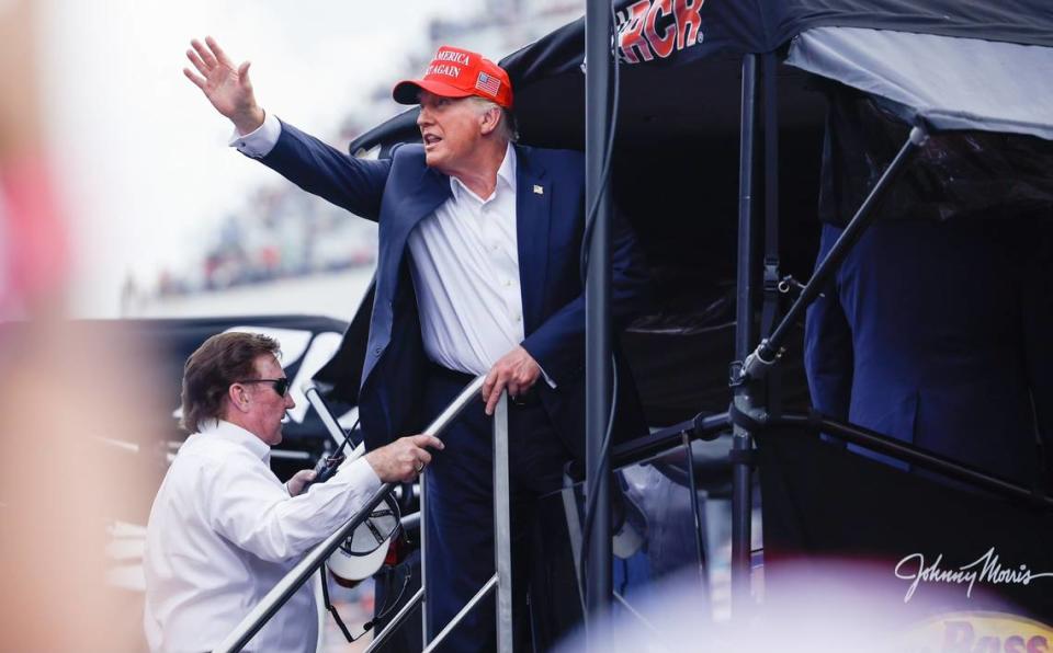 The former 45th President Donald Trump raises a fist to chanting supporters as he, and team owner Richard Childress, enter the bay for #3 driver Austin Dillon during the Coca-Cola 600 at Charlotte Motor Speedway in Concord on Sunday, May 26, 2024.