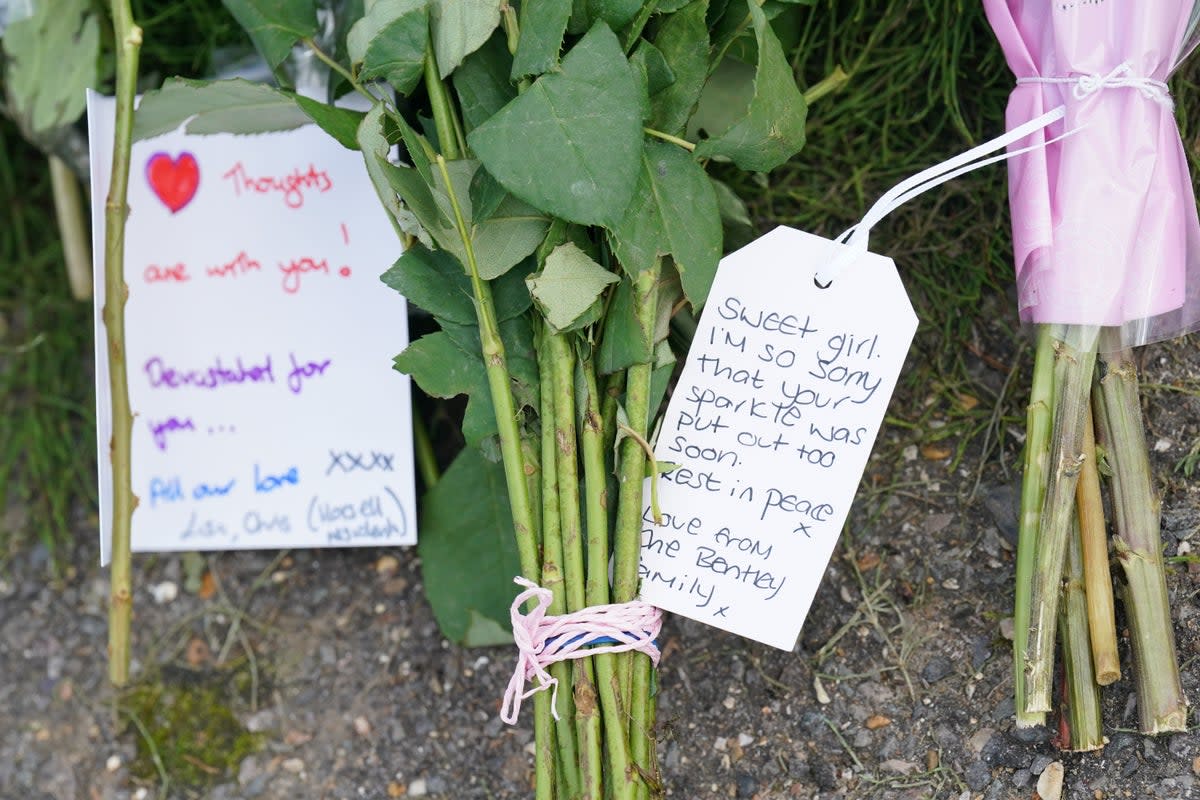 Notes left on flowers outside the house where the girl was found dead by police (Jonathan Brady/PA Wire)