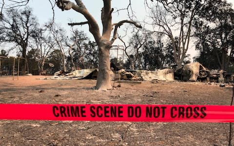 Police tape blocks the house where relatives say three people were found dead following a wildfire in Redding - Credit: Jonathan Cooper/AP