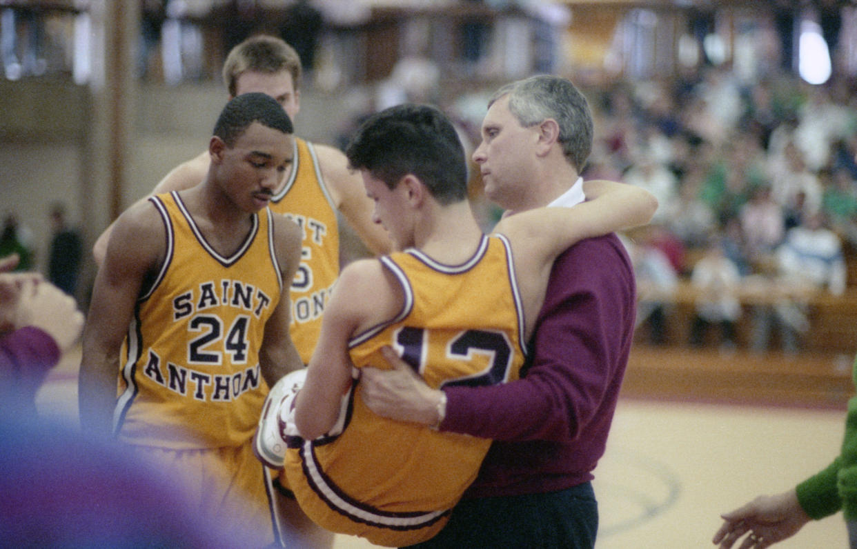 March 11, 1990: Lincroft, NJ, USA: St. Anthony High School's boys basketball team of Jersey City competes for the Parochial B State championship against St. Peter's of New Brunswick in Lincroft on March 11, 1990. Injured point guard Dan Hurley is carried from the court by his coach and father Bob Hurley Sr. Mandatory Credit: Linda Cataffo-USA TODAY NETWORK