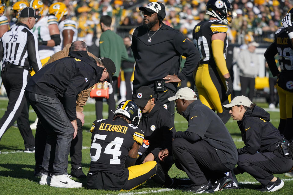 Pittsburgh Steelers linebacker Kwon Alexander (54) is examined by team trainers and doctors after being injured on a play as head coach Mike Tomlin, top center, looks for a replacement during the first half of an NFL football game against the Green Bay Packers in Pittsburgh, Sunday, Nov. 12, 2023. (AP Photo/Gene J. Puskar)