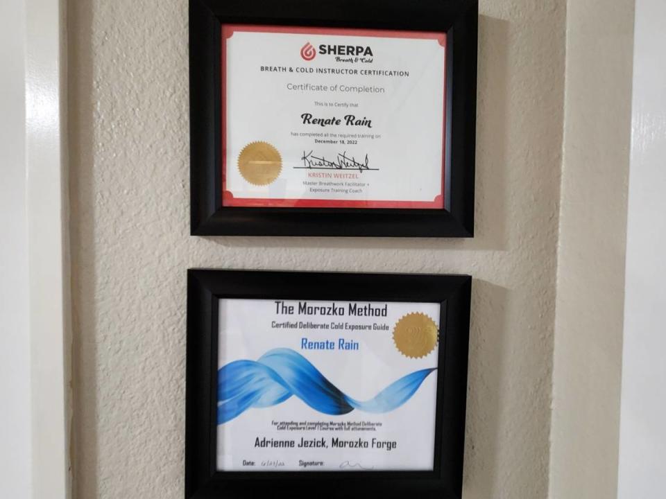 Two program certificates hang on a wall inside Renate Rain’s home on May 1, 2023, in University Place. The top program, Sherpa Breath & Cold, provides training and certification for breathwork and ice bath coaching. The bottom program, the Morozko Method, endorses a meditation technique to help plungers stay calm and heighten their sensory immersion while in cold water.